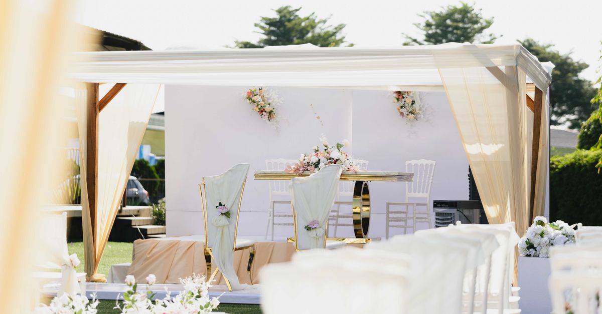 Beautiful outdoor wedding ceremony setting with white and pastel-colored decor and floral arrangements.